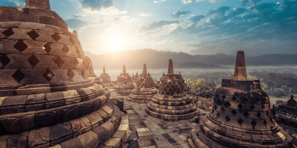 Amazing view of stone stupas at ancient Borobudur Buddhist temple against beautiful landscape on background. Great religious architecture. Magelang, Central Java, Indonesia