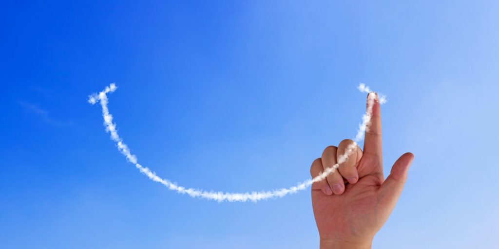 Happiness concept, hand drawing smile cloud on blue sky background